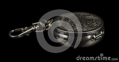 Round portable ashtray made of metal with patterns on the lid and with a carabiner for fastening Stock Photo