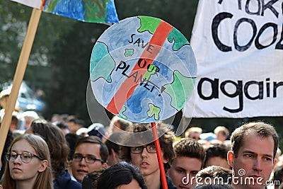 Round protest sign in the shape of planet earth saying `Save our planet` held up by young people during Global Climate Strike even Editorial Stock Photo