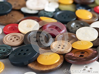 Round sewing buttons of different colours and sizes, close up. Variety of colored flat buttons with two or four holes Stock Photo