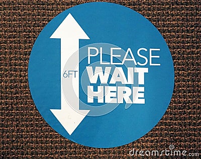 Social distancing PLEASE WAIT HERE sign Stock Photo