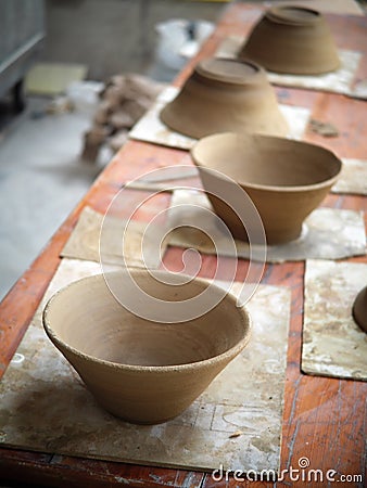 Round soft brown color formed clay for ceramic utensils bowls under production process in a factory Stock Photo