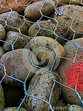 Round stones laid in gabion Stock Photo