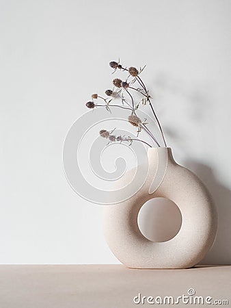 Round stylish ceramic vase with dried plant Stock Photo