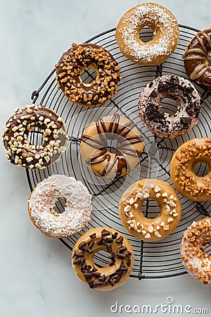 A round vintage cooling rack topped with assorted decorated homemade donuts. Stock Photo