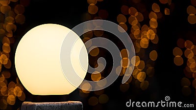 Round white street lamp shines with warm glow. Stock Photo