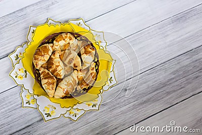 Round wicker basket with croissants on yellow cloth Stock Photo