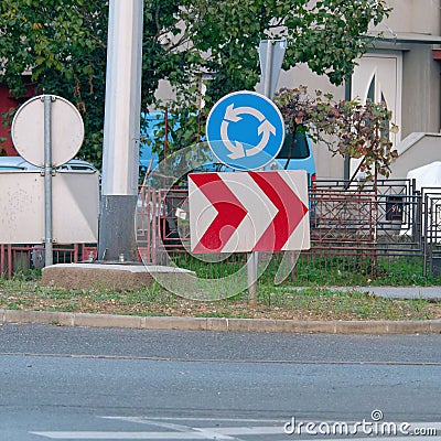 Roundabout and a red and white chevron right sign on the road Stock Photo