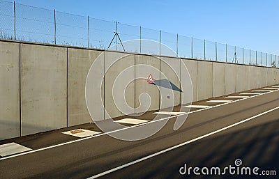 Roundabout warning triangle road sign, on concrete wall at the exit of the underpass. Stock Photo