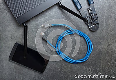 Router, smartphone, cable to connect and crimper on grey Stock Photo