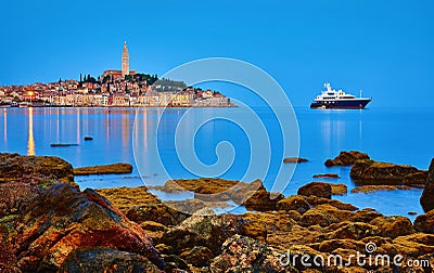 Rovinj, Croatia. Antique medieval old town nighttime view. Luxury yacht and fishing sea. Big stones Stock Photo