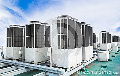 A row of air conditioning units on rooftop with blue sky Stock Photo