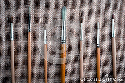 Row of artist paintbrushes closeup on sack, retro stylized Stock Photo