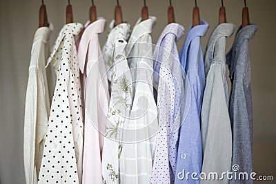 A row of assorted business shirts for women on hangers in a closet Stock Photo