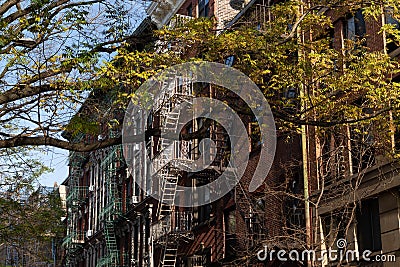 Row of Beautiful Old Residential Buildings with Fire Escapes in Nolita of New York City with a Colorful Tree during Autumn Stock Photo