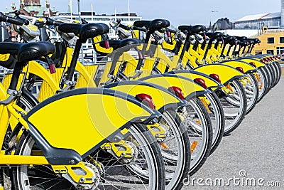 Row of bicycles parked. Row of parked colorful bicycles. Rental yellow bicycles. Pattern of vintage bicycles bikes for rent Stock Photo