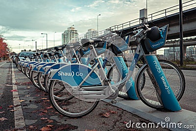 Row of blue Shaw Go Mobi bikes lined up near skytrain in Downtown Vancouver Canada Editorial Stock Photo