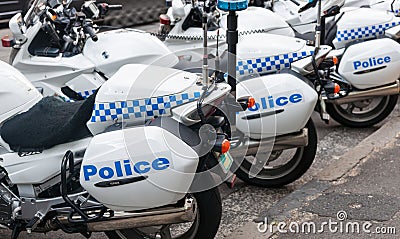 Row of blue and white police motor cycles parked in city street Editorial Stock Photo