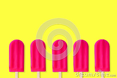 Row of pink popsicles on a yellow background Stock Photo