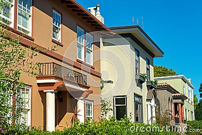 Row of brown beige and green house exteriors or facades in downtown neighborhood in suburban area of the city Stock Photo