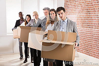 Row Of Businesspeople Standing With Cardboard Boxes Stock Photo
