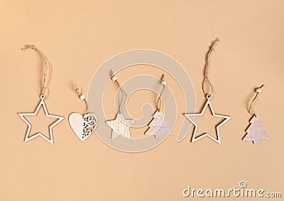 Row of Christmas festive craft decorations - wooden stars, Xmas trees, hearts on beige background with copy space. Stock Photo