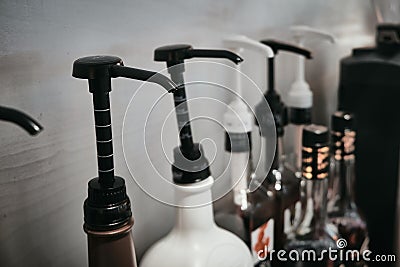 Row of coffee flavoring syrup bottles with dispenser Stock Photo