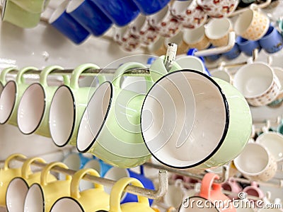 A row of colorful cups hanging on a rack Stock Photo