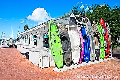 A row of colorful kayaks standing upright against a building at a marina in Islamorada, Florida Editorial Stock Photo