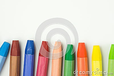 Row of Colorful Multicolored Pastel Wax Crayons on White Paper. Back to School Kids Arts Creativity Drawing Hobby Concept Stock Photo