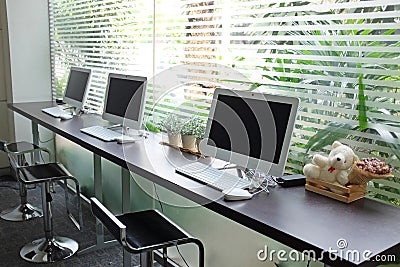 Row of computers waiting for people use at internet cafe Stock Photo