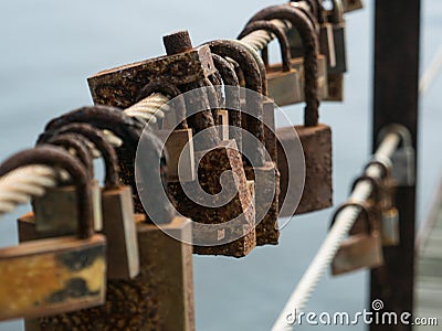 Row of corroded, rusty love locks / padlocks attached to bridge in Portugal. Stock Photo