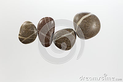 Row of dark pebbles with white veins and a light background Stock Photo