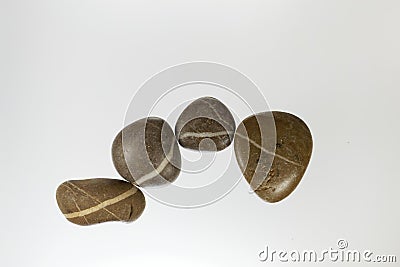 Row of dark pebbles with white veins and a light background Stock Photo