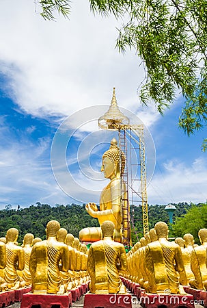 Row of disciple statues surrounding big buddha statue Stock Photo