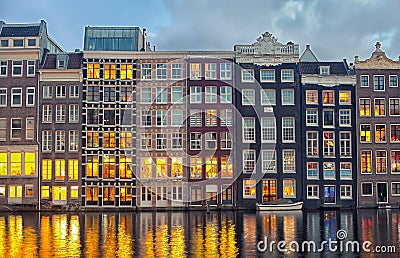 Row of Dutch houses at Central canal Damrak Amsterdam, Netherlands at twilight Stock Photo