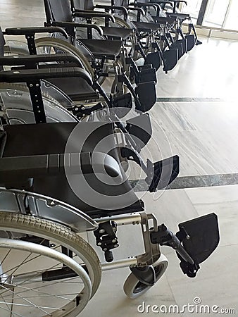 Row of empty wheelchairs in airport hall. Wheelchair service for disabled passengers or passengers with reduced mobility in the Stock Photo
