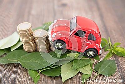 A row of euro coins surrounded by fresh green leaves and cars climbing on them Stock Photo