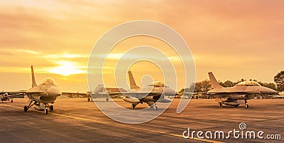 Row of fighter jet military aircraft parked on runway on sunset Stock Photo