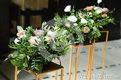 A row of flower arrangements as an element of decor on golden centerpieces Stock Photo