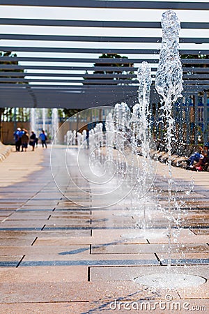 Row of fountains in a park at a high shutter speed freezing the motion of the water and suspended droplets with variety of shape, Stock Photo
