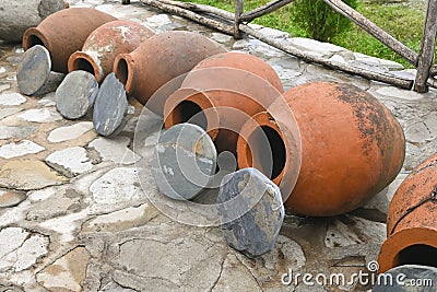 Row of Georgian traditional wine making clay vessels kvevri Stock Photo