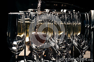 A row of glasses filled with champagne are lined up ready to be served Stock Photo