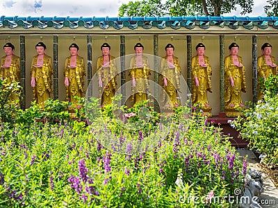 Row of golden Buddha statues with swastika symbol Editorial Stock Photo