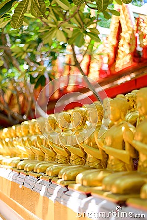 Row of golden buddha statues at temple Stock Photo