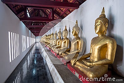 Row of golden buddha statues in the terrace of Wat Phra Sri Rattana Mahathat , Wat Yai or Wat Buddha Chinnarat temple Stock Photo
