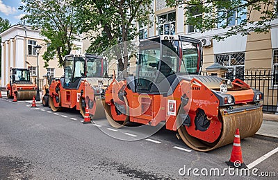Row of heavy vibratory rollers in the city street ready for asphalt paving, construction and repair equipment: Moscow, Russia - Editorial Stock Photo