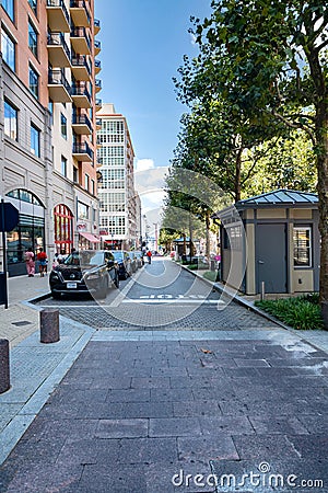 Row of high-rise brick houses on the street leading to NATIONAL HARBOR. Pavement and road with parking Editorial Stock Photo