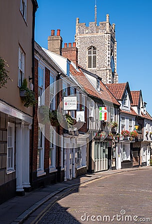 Row of historic characterful buildings in Tombland, Norwich city centre, Norfolk UK. Church spire behind. Editorial Stock Photo