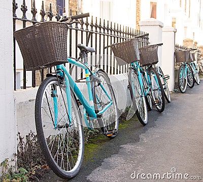 Row of matching rental student bicycles with baskets Stock Photo