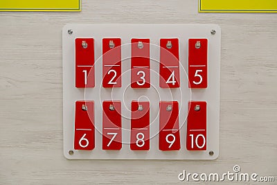 Row of metal lockers with locks, keys and numbered red tags in a sports changing room for securing personal effects Stock Photo